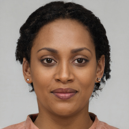 Joyful black young-adult female with short  black hair and brown eyes