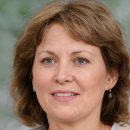 Joyful white adult female with medium  brown hair and grey eyes