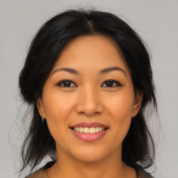 Joyful asian young-adult female with medium  brown hair and brown eyes