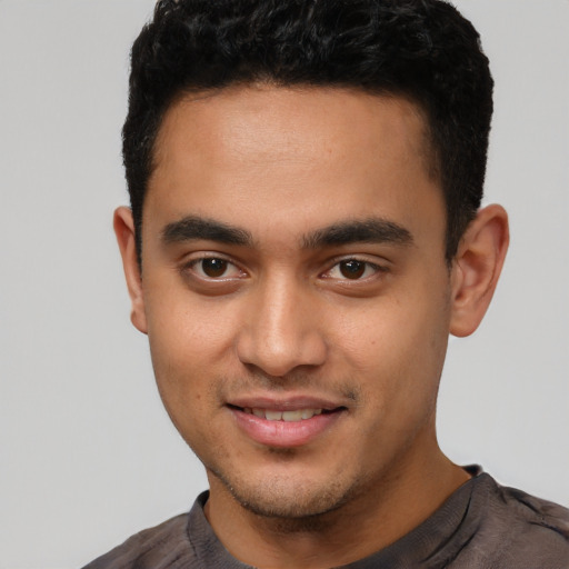 Joyful latino young-adult male with short  brown hair and brown eyes