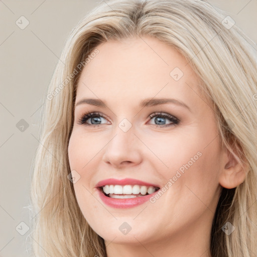 Joyful white young-adult female with long  brown hair and blue eyes