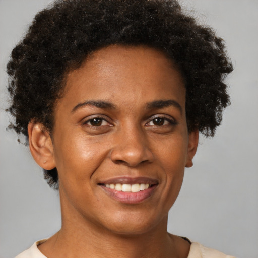 Joyful black young-adult female with short  brown hair and brown eyes
