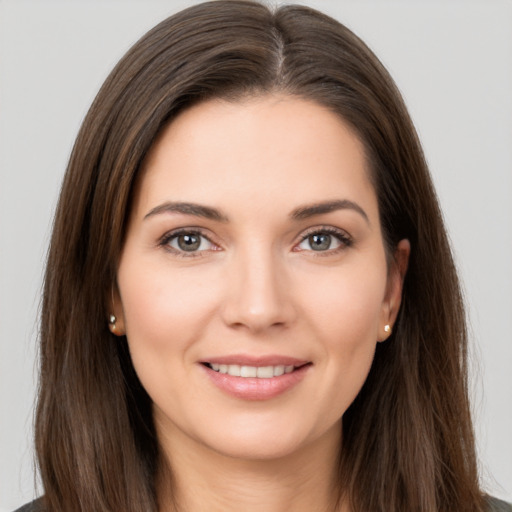 Joyful white young-adult female with long  brown hair and brown eyes