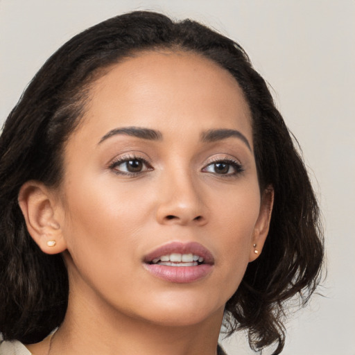 Joyful latino young-adult female with medium  brown hair and brown eyes