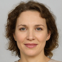 Joyful white young-adult female with medium  brown hair and green eyes