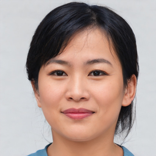 Joyful asian young-adult female with medium  black hair and brown eyes