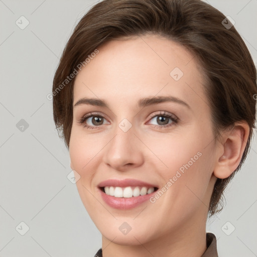 Joyful white young-adult female with medium  brown hair and grey eyes