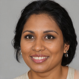 Joyful black adult female with medium  brown hair and brown eyes