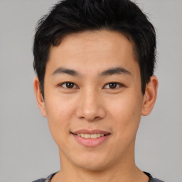 Joyful asian young-adult male with short  brown hair and brown eyes