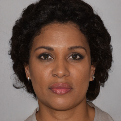 Joyful black adult female with short  brown hair and brown eyes