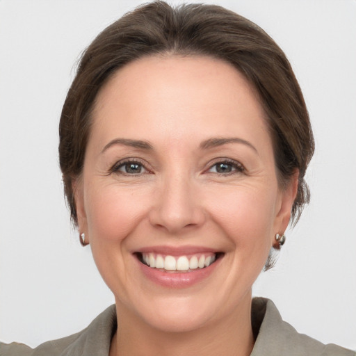 Joyful white adult female with medium  brown hair and grey eyes