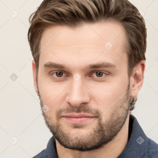 Joyful white young-adult male with short  brown hair and grey eyes