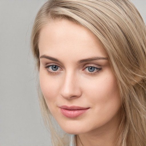 Joyful white young-adult female with long  brown hair and blue eyes