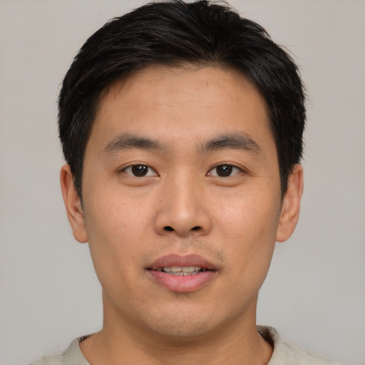 Joyful asian young-adult male with short  brown hair and brown eyes