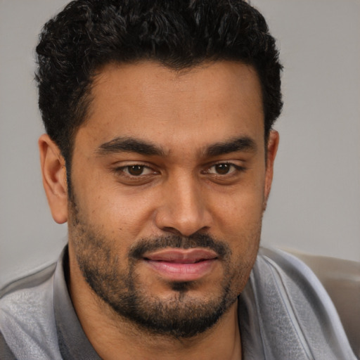 Joyful black young-adult male with short  black hair and brown eyes