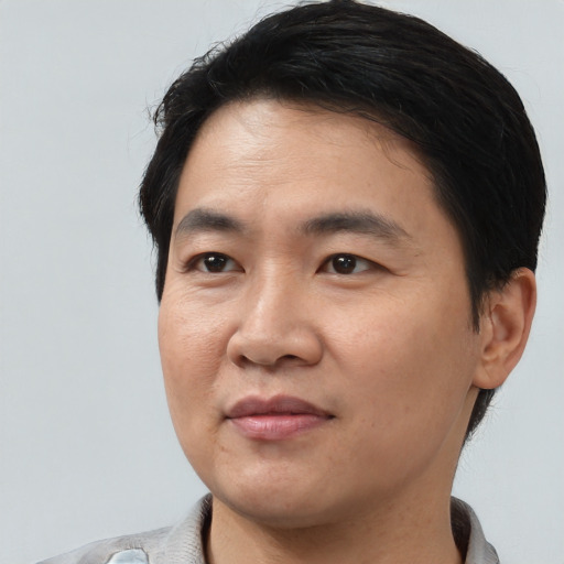 Joyful asian young-adult male with short  black hair and brown eyes