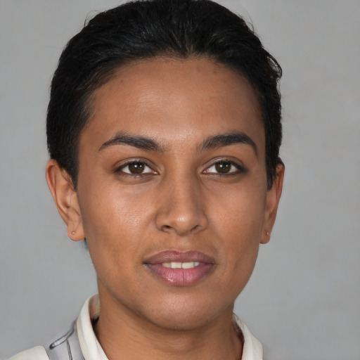 Joyful latino young-adult female with short  brown hair and brown eyes