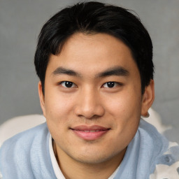 Joyful asian young-adult male with short  black hair and brown eyes