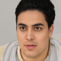 Joyful latino young-adult male with short  black hair and brown eyes