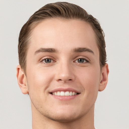 Joyful white young-adult male with short  brown hair and grey eyes