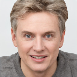 Joyful white adult male with short  brown hair and blue eyes
