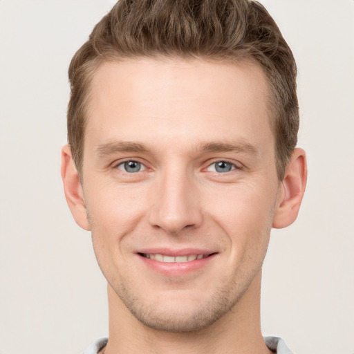 Joyful white young-adult male with short  brown hair and grey eyes