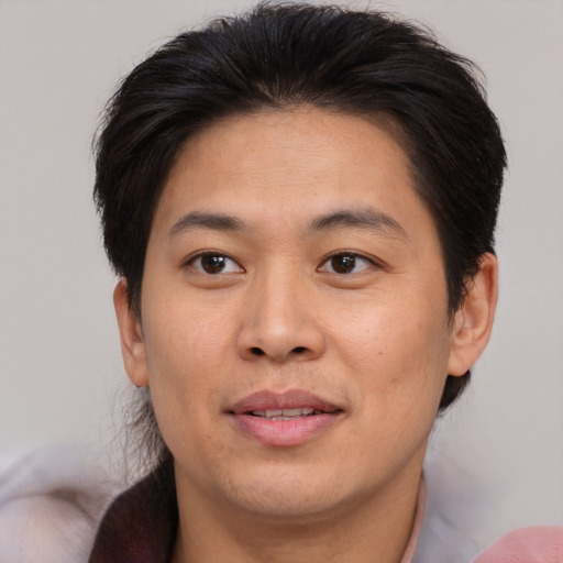 Joyful asian adult male with medium  brown hair and brown eyes
