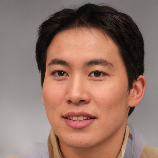 Joyful asian young-adult male with short  brown hair and brown eyes