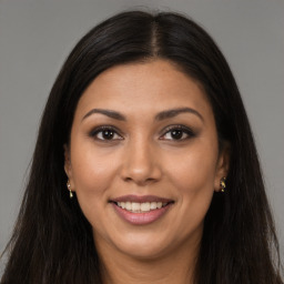 Joyful latino young-adult female with long  brown hair and brown eyes