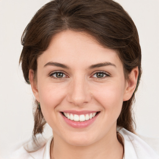 Joyful white young-adult female with medium  brown hair and grey eyes