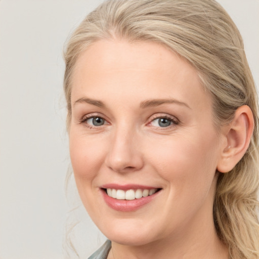 Joyful white young-adult female with medium  brown hair and blue eyes