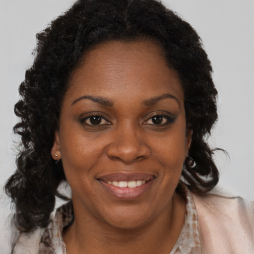 Joyful black young-adult female with long  brown hair and brown eyes