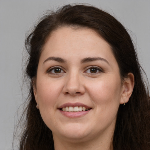 Joyful white young-adult female with long  brown hair and brown eyes