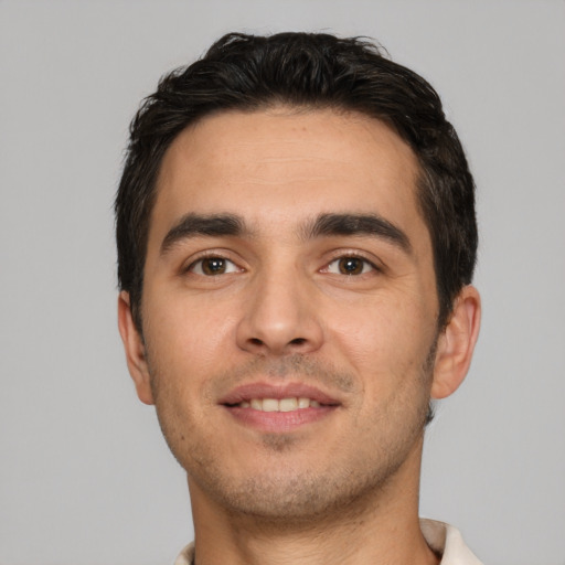 Joyful white young-adult male with short  brown hair and brown eyes