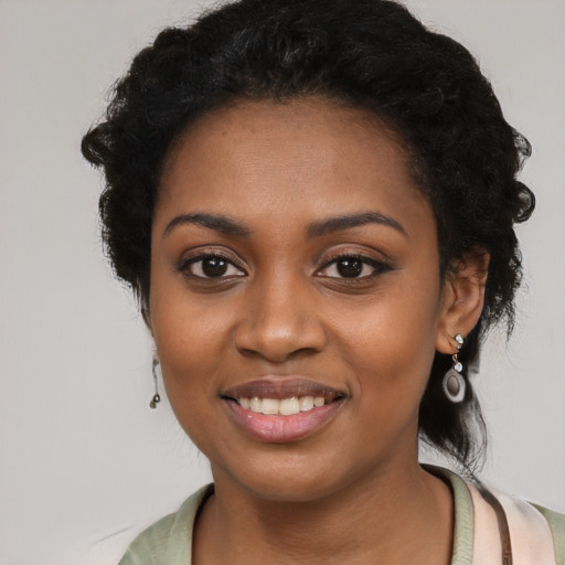 Joyful black young-adult female with long  black hair and brown eyes