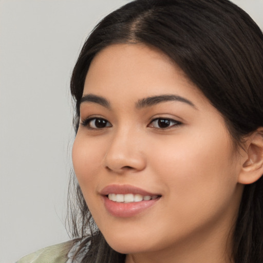 Joyful latino young-adult female with long  brown hair and brown eyes