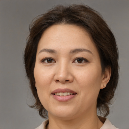 Joyful white adult female with medium  brown hair and brown eyes