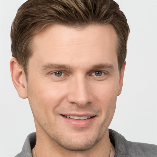 Joyful white young-adult male with short  brown hair and grey eyes