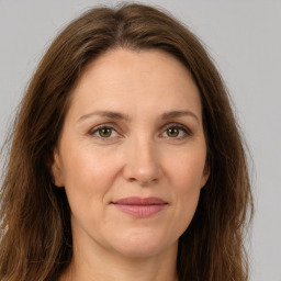 Joyful white adult female with long  brown hair and green eyes