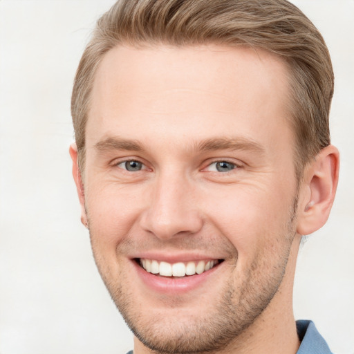 Joyful white young-adult male with short  brown hair and grey eyes