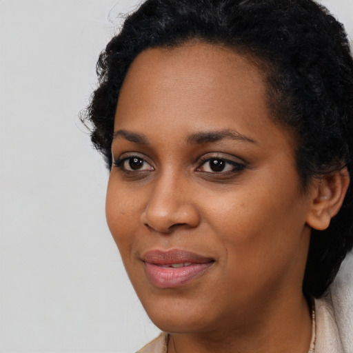 Joyful black young-adult female with long  black hair and brown eyes