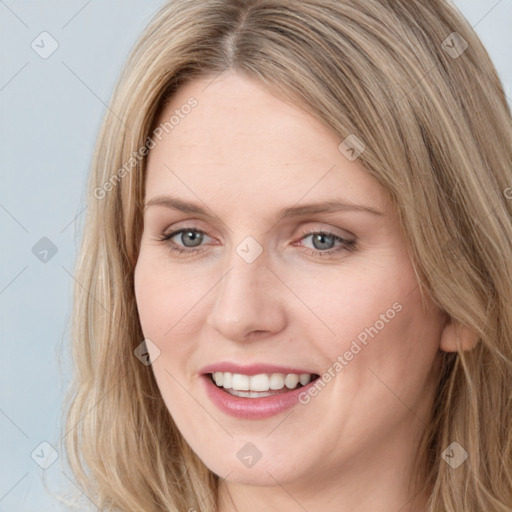 Joyful white young-adult female with long  brown hair and blue eyes