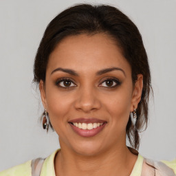 Joyful latino young-adult female with medium  brown hair and brown eyes