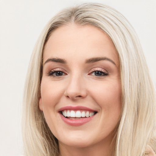 Joyful white young-adult female with long  brown hair and blue eyes