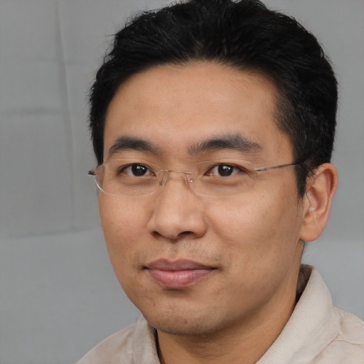 Joyful asian adult male with short  black hair and brown eyes