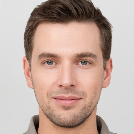 Joyful white young-adult male with short  brown hair and grey eyes