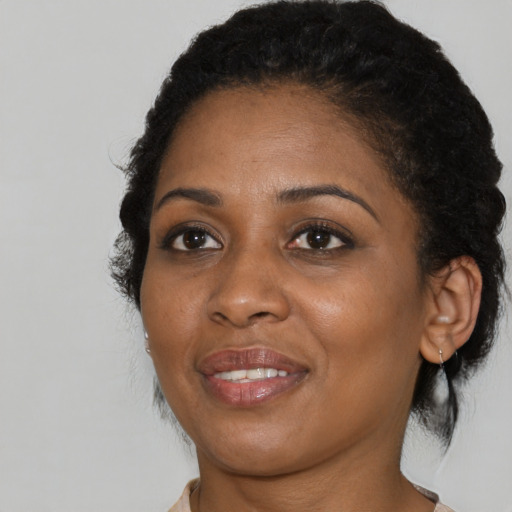 Joyful black young-adult female with medium  brown hair and brown eyes