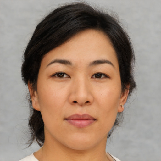 Joyful asian adult female with medium  brown hair and brown eyes