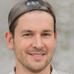 Joyful white adult male with short  brown hair and grey eyes