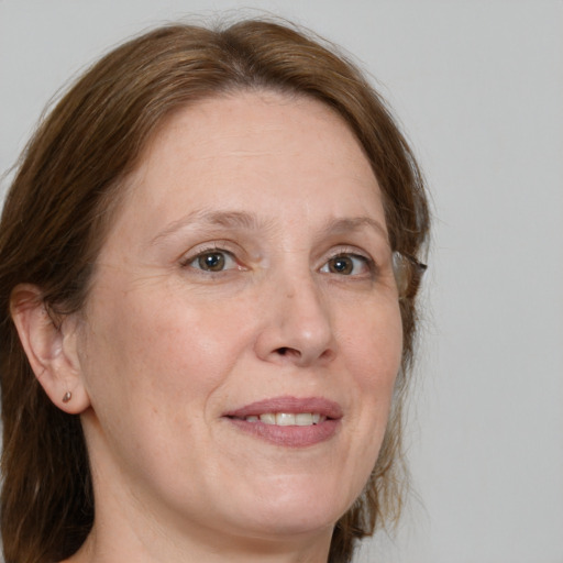 Joyful white adult female with medium  brown hair and green eyes